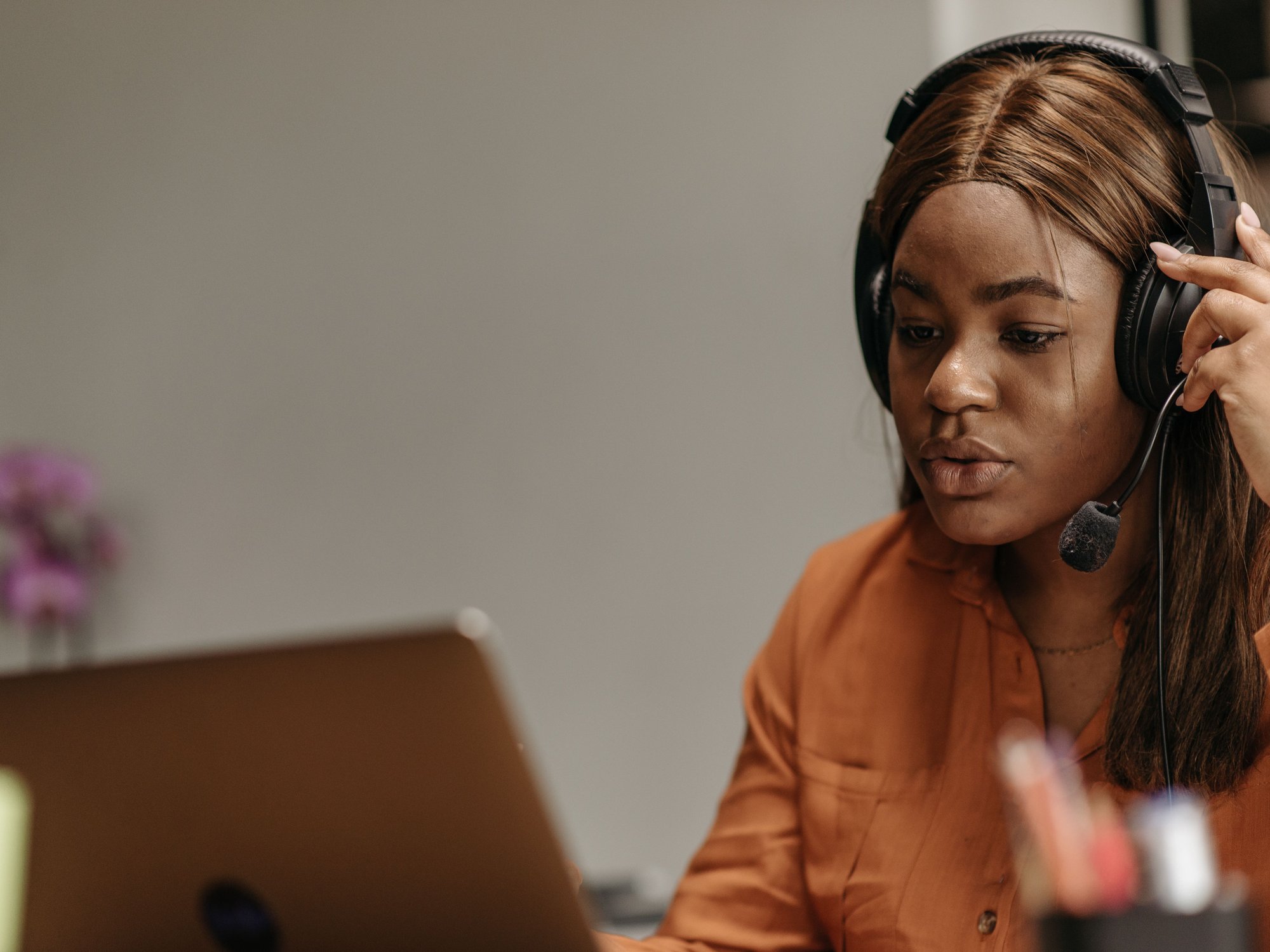 Person using a headset while working at a laptop